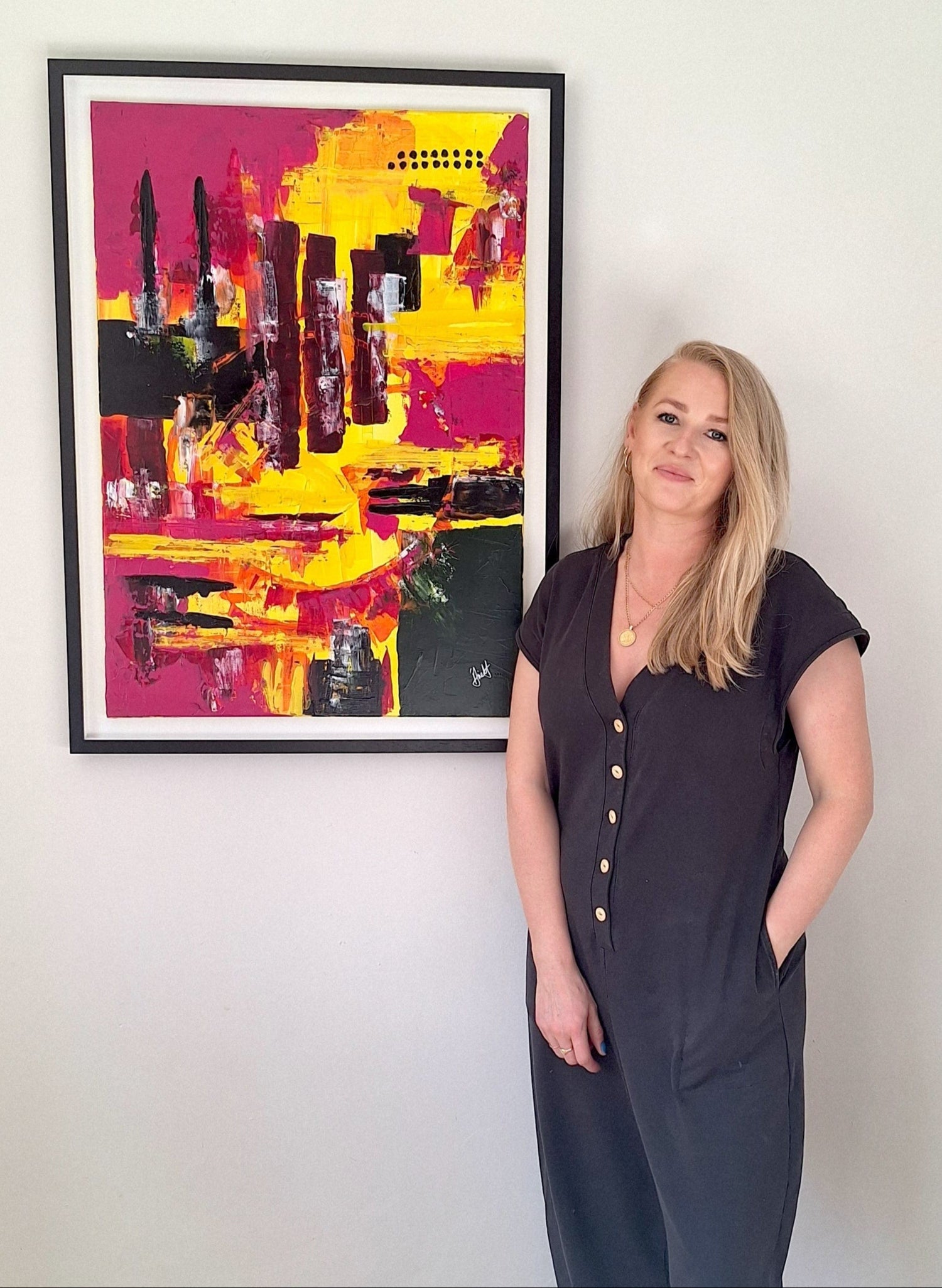 Aine Hayes an Irish abstract artist standing in front of her abstract art piece titled Let The Sun In